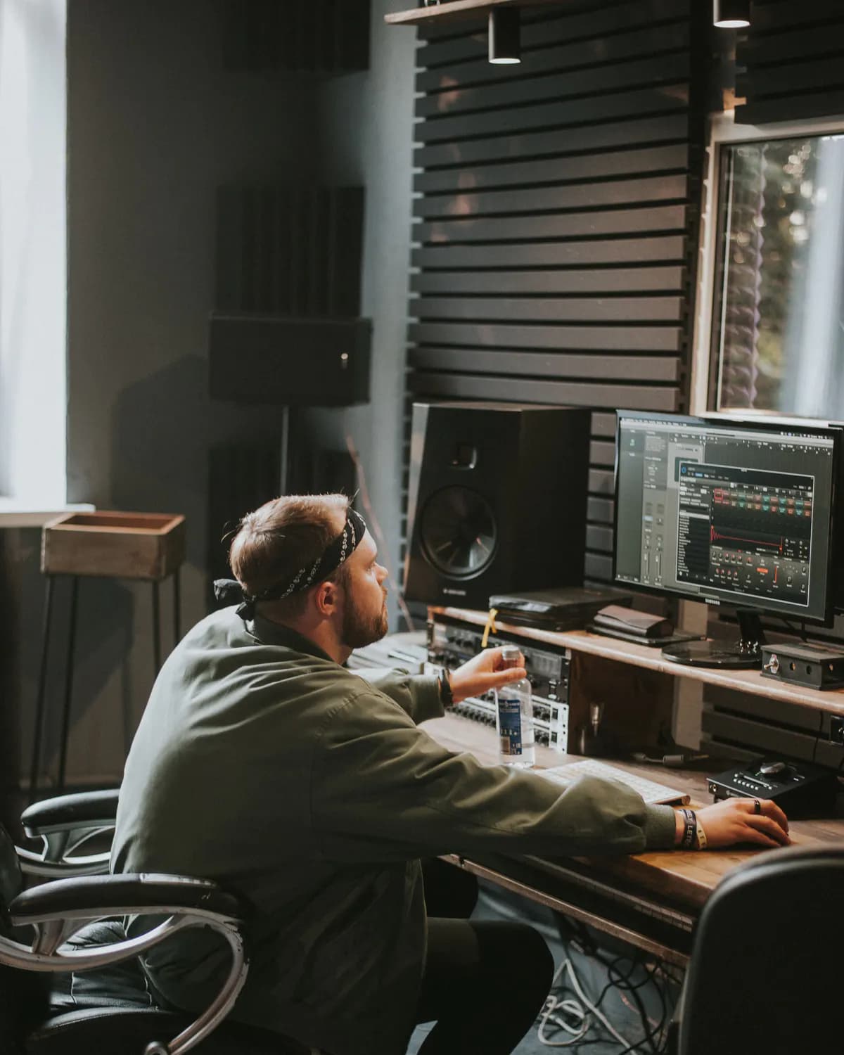 A producer working with audio software in a recording studio